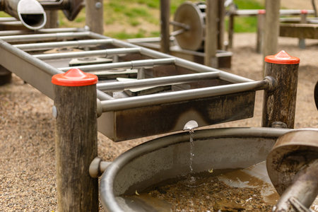 A water play station at a playground invites children to explore and engage with flowing water. Kids can observe the movement of water while playing with the interactive features and elementsの写真素材