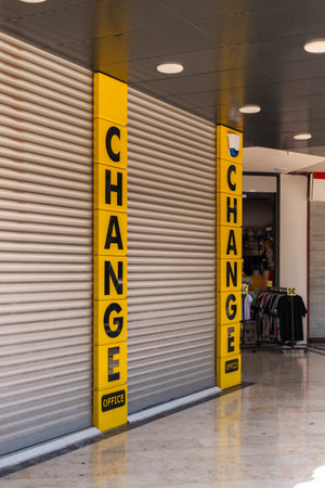 Bright yellow signs reading CHANGE indicate a currency exchange office. The shop is closed, with a...