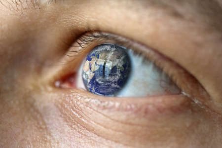 Close-Up of a male face with the earth in the eye (asia view). Symbolise Hope, fear of climate change, natural disasters like flood の写真素材