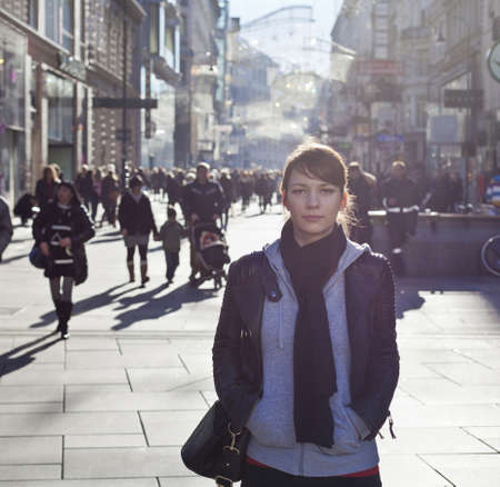 Urban girl standing out from the crowd at a city street のeditorial素材