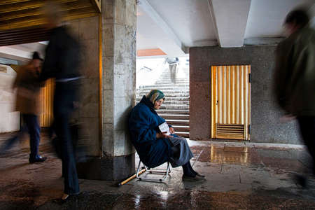 A beggar woman sitting on a rainy day in an underground passage passing the 4 5 km long main street Nevsky Prospect in the historic center of St  Petersburg in Russia  Nevsky Prospect is one of the most famous streets of Russia with  thousands of people oのeditorial素材
