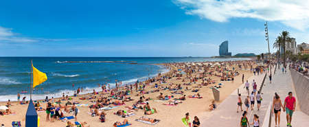 Crowded beach of Barceloneta with modern hotel W in the background in summer time. Barceloneta Beach is one of the most popular beach in the city of barcelona - Spainのeditorial素材