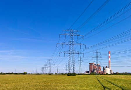 Electricity pylons with power a station in the middle of a agricultural field  track in the field leading towards.の写真素材