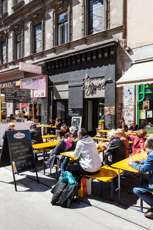 Some people enjoy a sunny day at the popular Viennese shopping street Neubaugasse. The street is small but always busy and full of little shops, theaters, culture and flea markets twice a year, which extends over the entire Neubaugasse.のeditorial素材