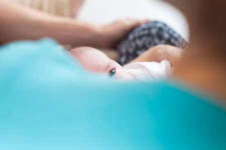 Newborn baby on mothers arm get cared and breast-feeded