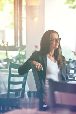 Portrait of a happy young woman sitting in a restaurant