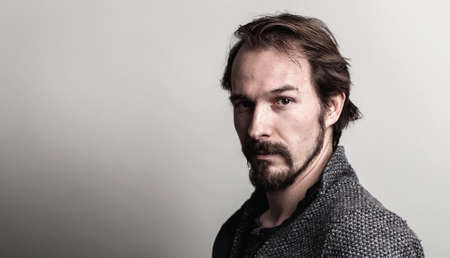 Portrait of a handsome serious and casual young man against grey background.の写真素材