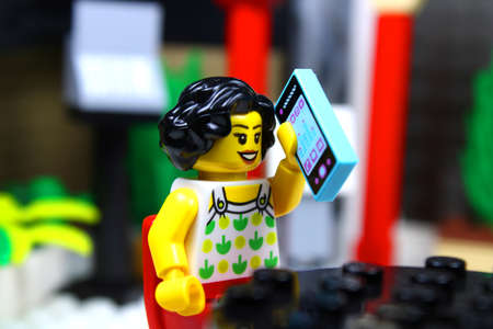 Detroit, USA - June 8, 2020: Woman making a phone call in a restaurant. Lego minifigures. Studio shot.のeditorial素材
