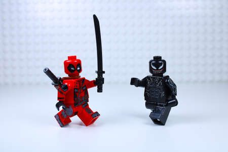 Detroit, USA - June 8, 2020: Two Lego mini-figure Deadpool fights Venom with his sword. Studio shot.