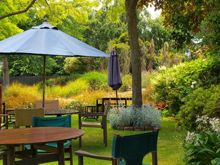 dining table in sunny garden patio with sunshadeの写真素材