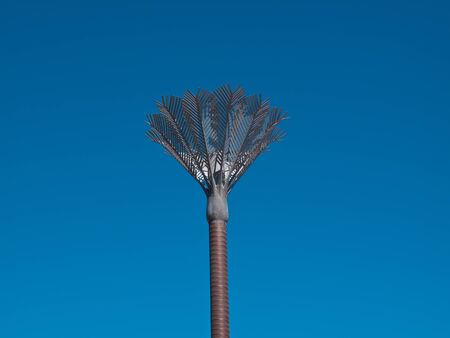 A lifesize sculpture of a palm tree against a blue sky