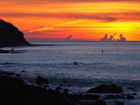 orange and yellow sunset over rocky outcropsの写真素材