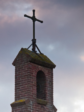 Cross on top of a european chapel under a dramatic skyの写真素材