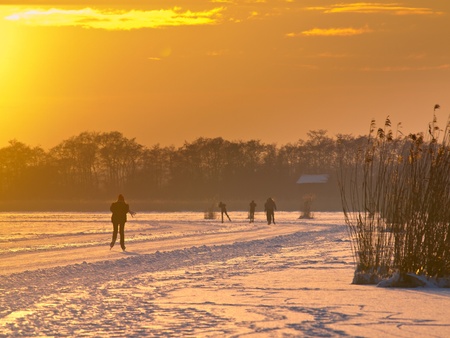 Ice skating on a frozen lake in the netherlandsの写真素材