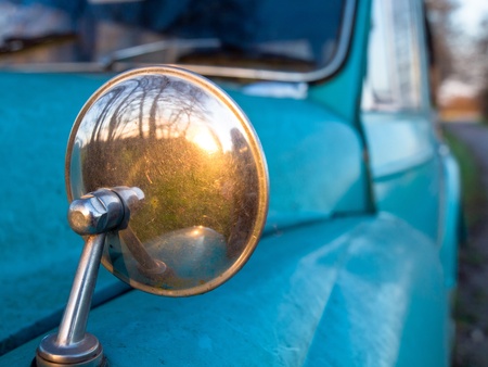 Rear view mirror on a vintage car resembling looking back in time, conceptの写真素材