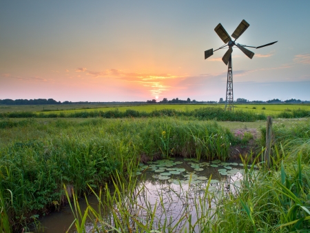 Old american windmill during sunset in dutch rural settingの写真素材