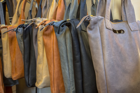 Handmade leather shoulder bags on display in a shop