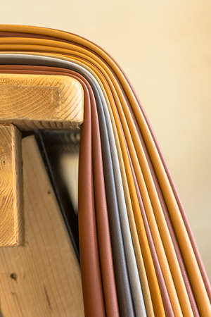Pieces of leather in various colors on a workbench in a handbag design studio