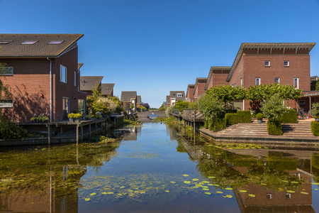 Street of ecological middle class family houses on the riverside in Kloosterveen, Assen Netherlandsの写真素材