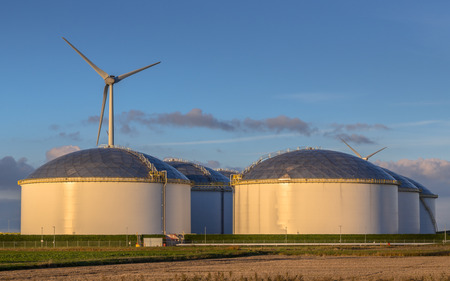 Giant modern oil storage tanks in an industrial harbor area with blue sky in the Netherlandsの写真素材