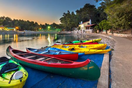 Colorful Kayaks for rent in a croatian bay at sunset under beatuful sky and lightingのeditorial素材