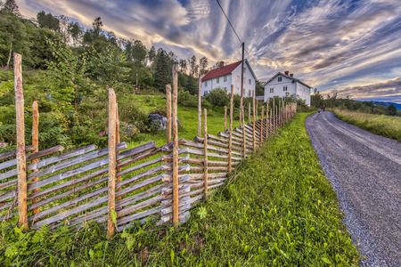 LILLEHAMMER, NORWAY - AUGUST 01, 2016: Norwegian House with traditional roundpole wooden fenceのeditorial素材