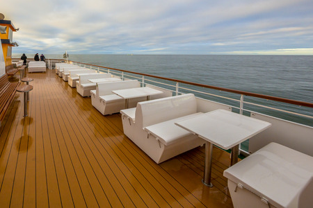 Outdoor Seats on passenger ship deck under blue sky with clouds