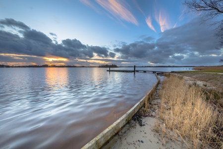 Sunset over camp shedding on the banks of lake Paterswoldsemeer in the Netherlandsの写真素材