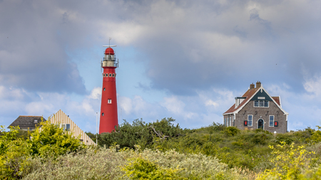 Red lighthouse between houses of village of Schiermonnikoog isandのeditorial素材