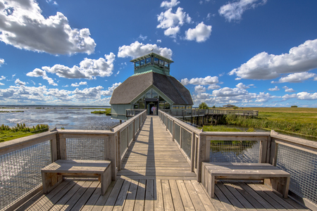 HORNBORGASJON, SWEDEN - JULY 26, 2016: Hornborgasjon visitor centre with Wooden boardwalk with seats in a marshland nature reserve in swedenのeditorial素材