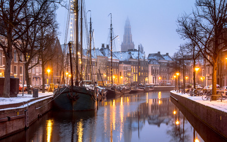 Historic sailing ships covered in snow at Hoge der Aa quay on Winterwelvaart festival in Groningen cityの写真素材