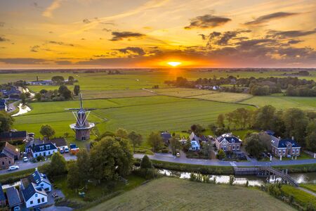 Aerial view of sunset over dutch village in agricultural countryside landscape, Groningen, Netherlands.の写真素材