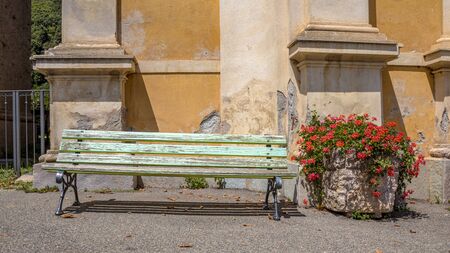 Weathered bench with flowers in front of church in a small village on Corsicaの写真素材