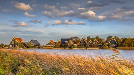 Traditional village scene with wooden houses on the waterfront in Groot Schermer, North Holland, Netherlandsの写真素材