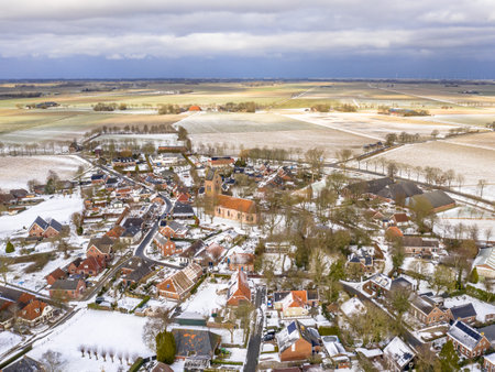 Aerial View over Village of Godlinze in Winter Landscape with Snow in the Province of Groningen, the Netherlandsの写真素材