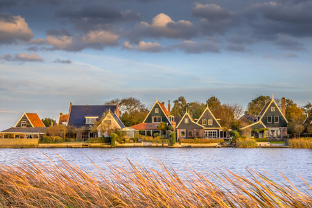 Traditional village scene with wooden houses on the waterfront in Groot Schermer, North Holland, Netherlandsの写真素材
