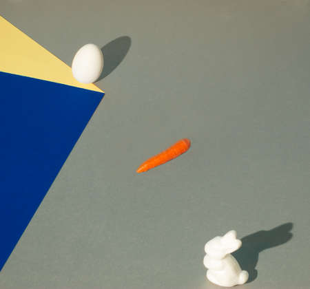 Easter bunny waits for a carrot and an egg falling down a paper cube. Creative optical illusion....