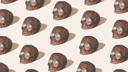 Pattern of brown skulls on beige background. Spooky Halloween or Santa Muerte concept. Minimal horror idea.の写真素材