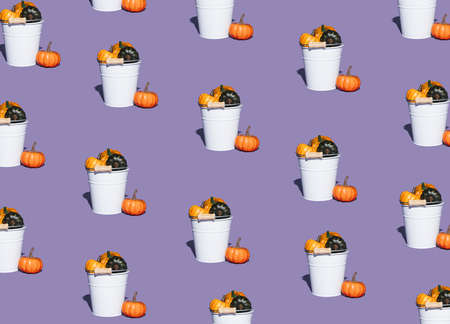Pattern made of white buckets filled with colorful autumn pumpkins on purple background. Minimal seasonal concept. Halloween or Thanksgiving composition.の写真素材