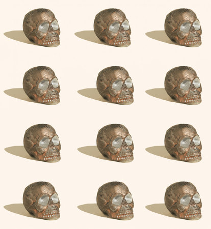 Pattern made of brown skulls on beige background. Spooky Halloween or Santa Muerte concept. Minimal horror idea.の写真素材