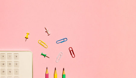 School calculator, pencils and paper clips on pink background. Back to school concept. Flat lay, top...