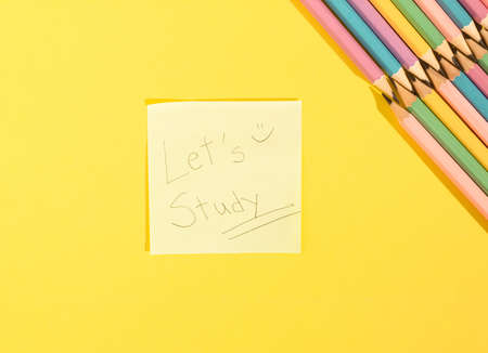 Close-up of information sign on paper. A sticky note  that encourages to study. Colored wooden...
