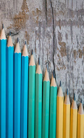 Colored pencils on wooden background. Top view with copy space. Flat lay. Back to school, education concept.の写真素材