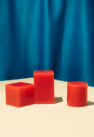 Minimal modern product display with red podiums on the table. Silk blue curtain background....