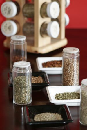 Spices with spice rack & red backgroundの写真素材