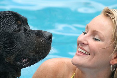 Woman swimming with rottweilerの写真素材