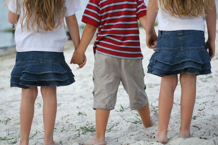 Children holding hands on the beachの写真素材