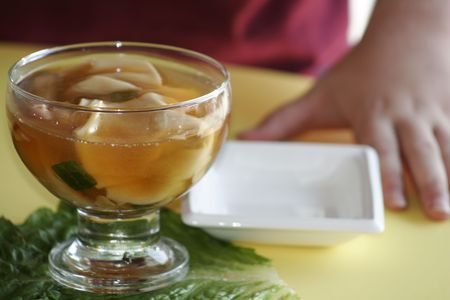 Wonton soup with childs handsの写真素材