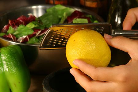 zesting a lemon with a microplane graterの写真素材