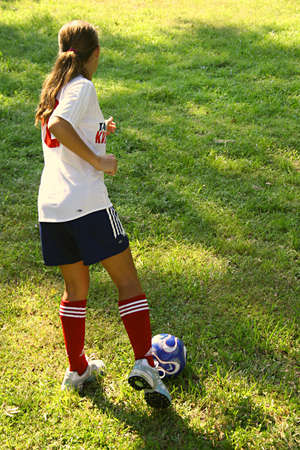 young girl ready to kick soccer ballの写真素材